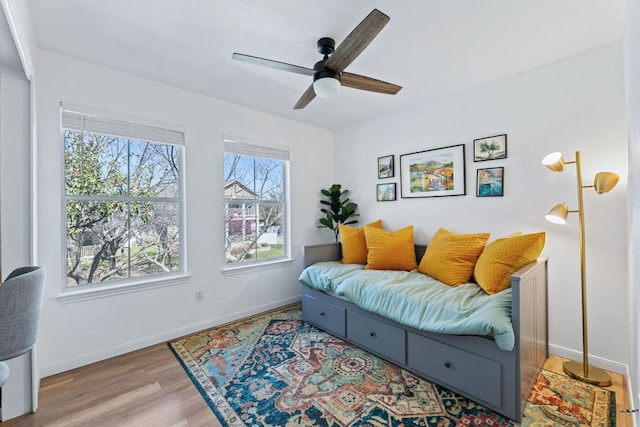 interior space with wood finished floors, baseboards, and ceiling fan