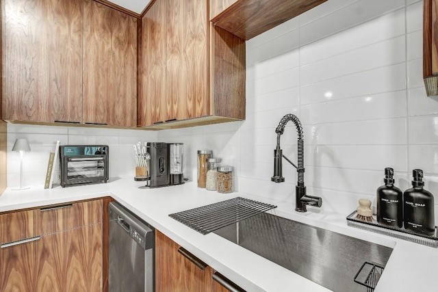 kitchen featuring a sink, light countertops, dishwasher, modern cabinets, and brown cabinets