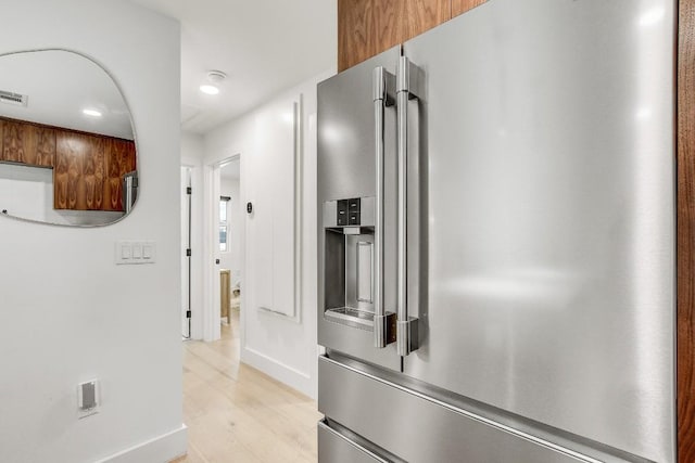 corridor featuring visible vents, light wood-style flooring, and baseboards