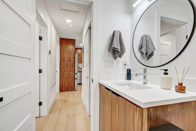 bathroom featuring recessed lighting, vanity, and wood finished floors