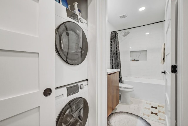 laundry area featuring visible vents and stacked washer and clothes dryer