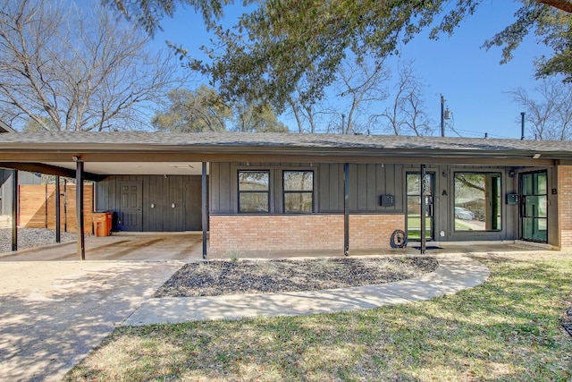 view of front of property with brick siding, board and batten siding, and concrete driveway