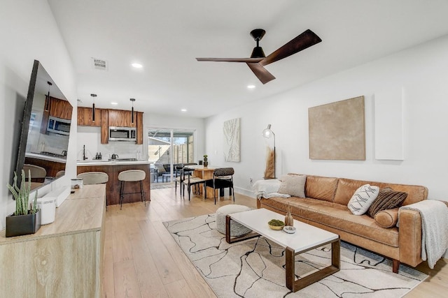 living area featuring ceiling fan, recessed lighting, visible vents, and light wood-type flooring