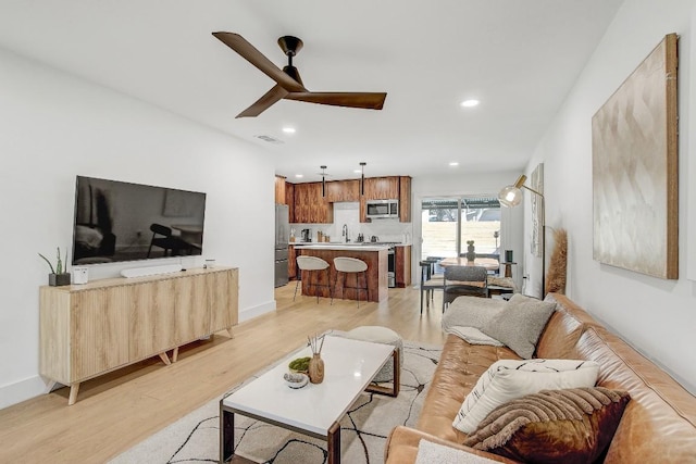 living room featuring light wood finished floors, visible vents, recessed lighting, and ceiling fan