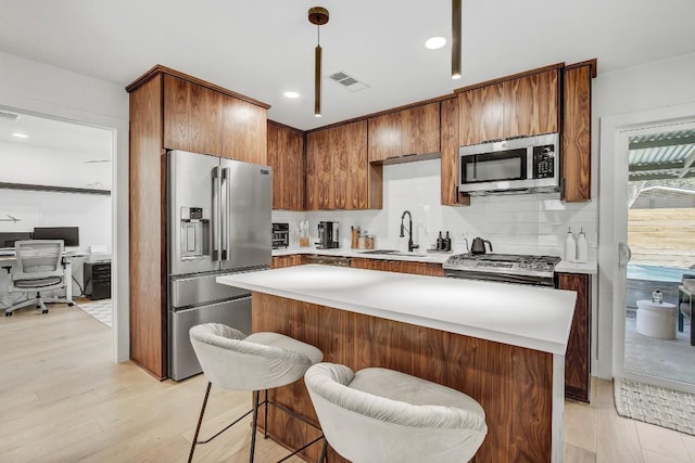 kitchen featuring visible vents, a sink, light countertops, appliances with stainless steel finishes, and backsplash