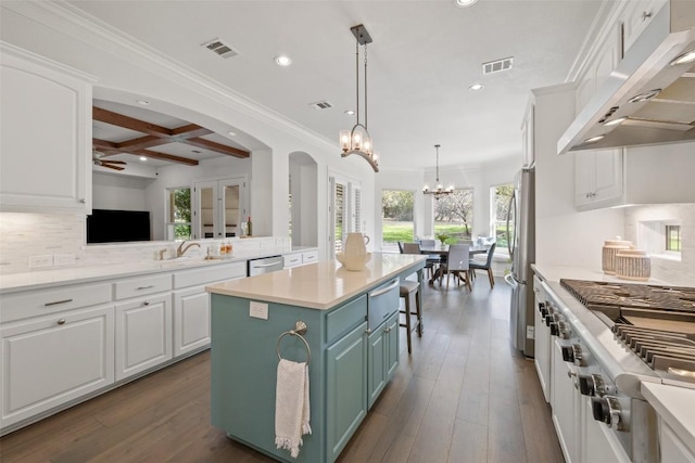 kitchen featuring visible vents, under cabinet range hood, a sink, coffered ceiling, and appliances with stainless steel finishes