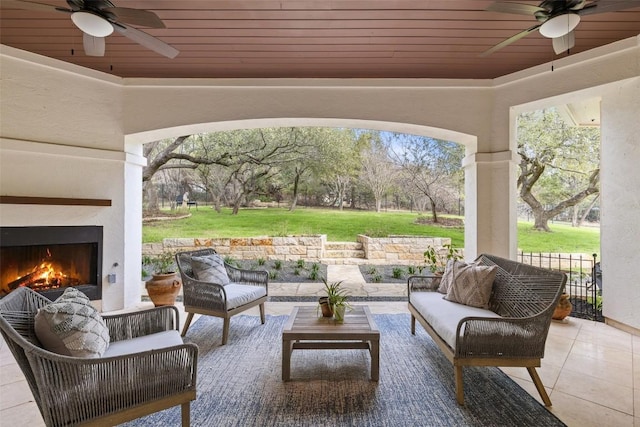 view of patio / terrace featuring an outdoor living space with a fireplace and ceiling fan