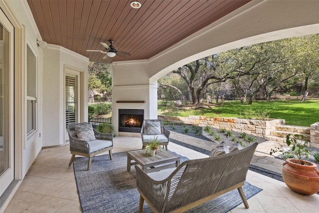 view of patio / terrace featuring an outdoor living space with a fireplace and ceiling fan