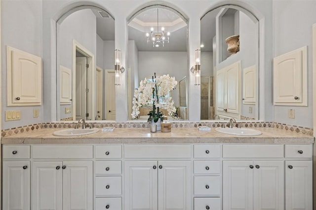 bathroom featuring a sink, a tray ceiling, visible vents, and double vanity