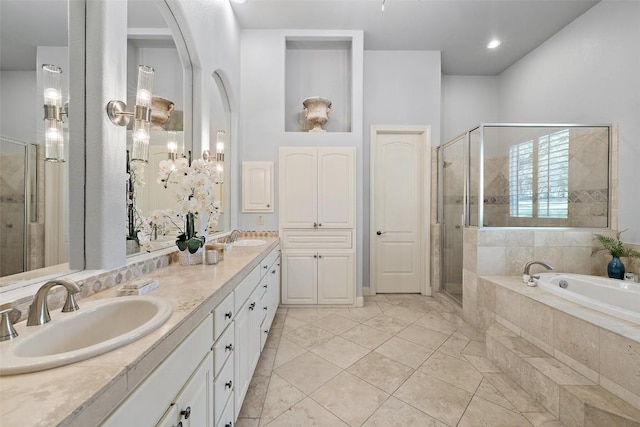 bathroom featuring a sink, a stall shower, double vanity, and a bath