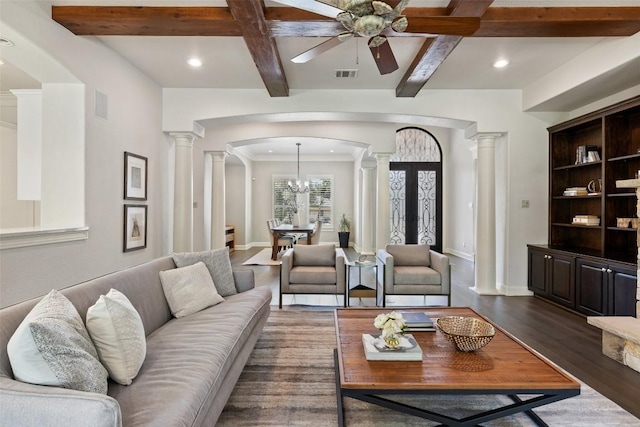 living room with visible vents, beamed ceiling, arched walkways, ornate columns, and dark wood-style flooring