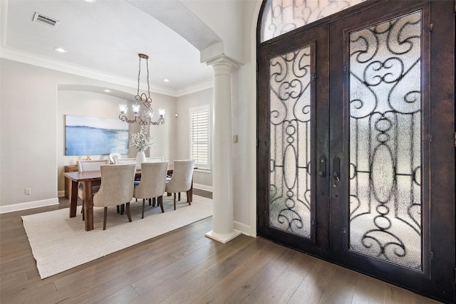 foyer featuring french doors, arched walkways, dark wood-type flooring, and visible vents