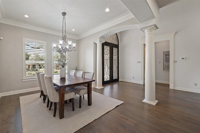 dining space with decorative columns, arched walkways, dark wood-type flooring, and baseboards