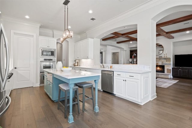 kitchen featuring visible vents, stainless steel appliances, coffered ceiling, white cabinetry, and dark wood-style flooring