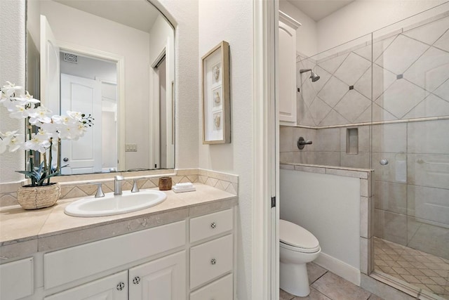 bathroom with tile patterned floors, a shower stall, toilet, and vanity