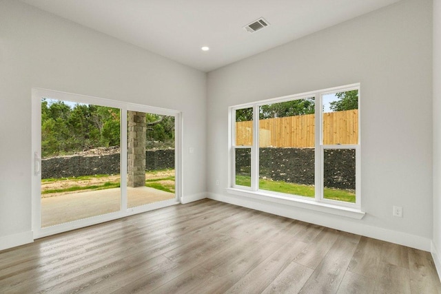 spare room featuring recessed lighting, visible vents, baseboards, and wood finished floors