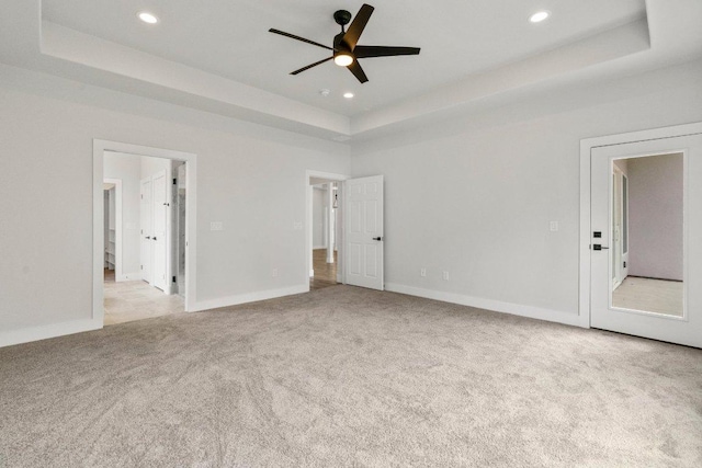 unfurnished bedroom with recessed lighting, a raised ceiling, and carpet floors