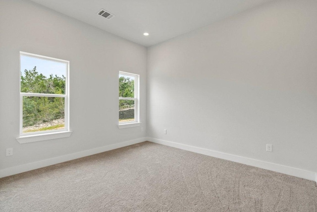 carpeted empty room with recessed lighting, visible vents, and baseboards