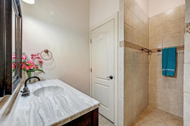 full bath with a tile shower and vanity