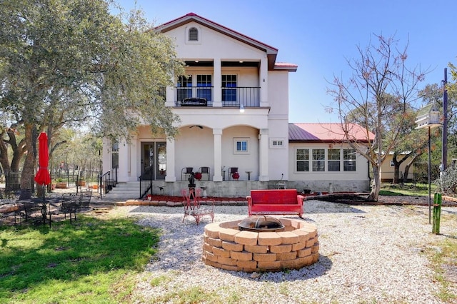 1401 Thurman Rd, San Marcos, TX 78666 - back of house with a balcony, an outdoor fire pit, stucco siding, and a porch