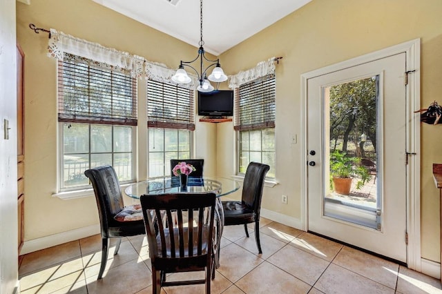 tiled dining area with a notable chandelier and baseboards