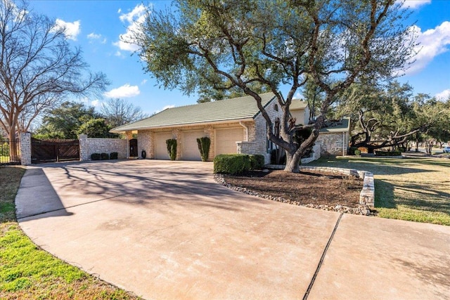 view of front of home with a gate, stone siding, fence, concrete driveway, and an attached garage