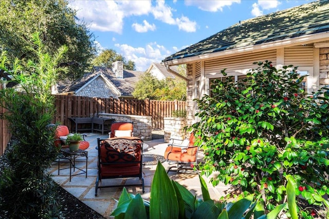 view of patio featuring fence and an outdoor hangout area