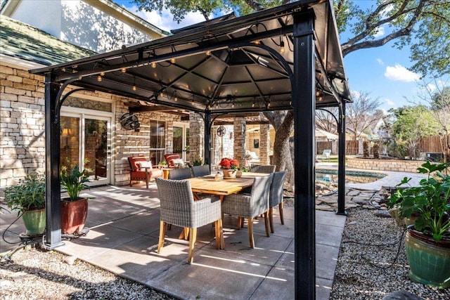 view of patio with a fenced in pool, outdoor dining area, and fence