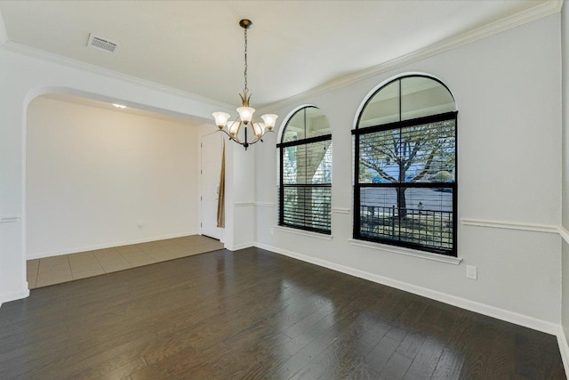 unfurnished room with an inviting chandelier, crown molding, dark wood-style floors, and visible vents