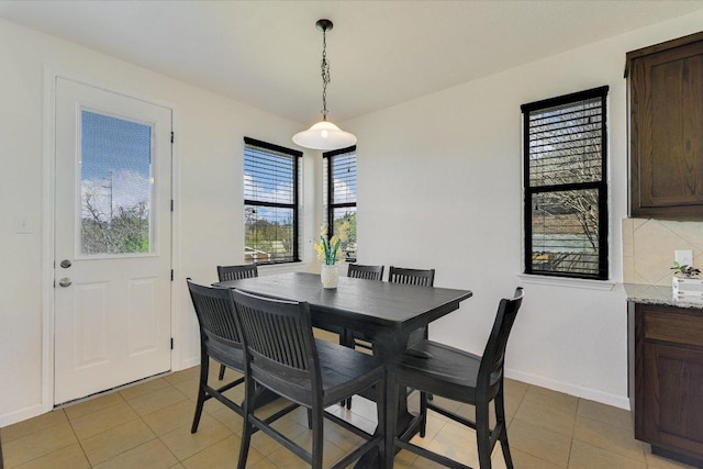 dining room with light tile patterned floors and baseboards