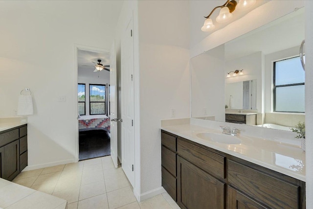 full bath with tile patterned flooring, two vanities, ensuite bathroom, and a sink