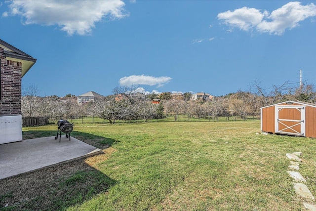 view of yard featuring an outbuilding, a storage shed, a fenced backyard, and a patio area