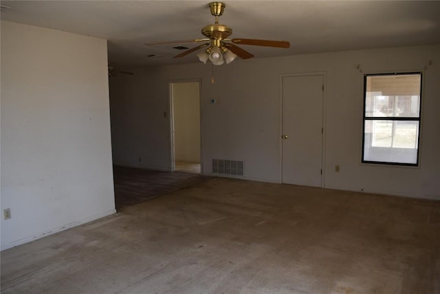 carpeted spare room featuring visible vents and ceiling fan