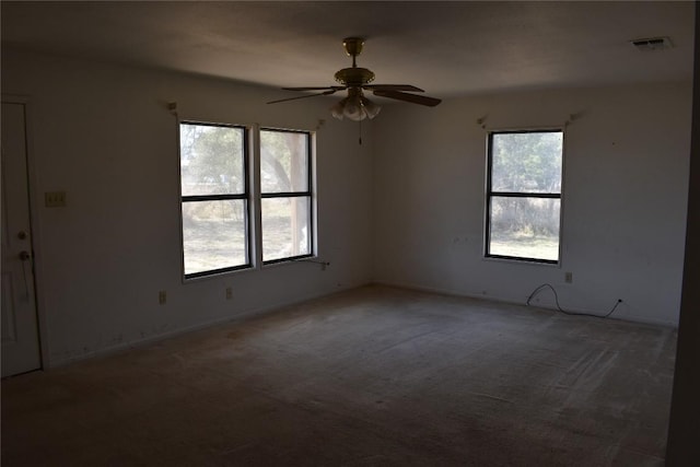 carpeted spare room with visible vents and ceiling fan