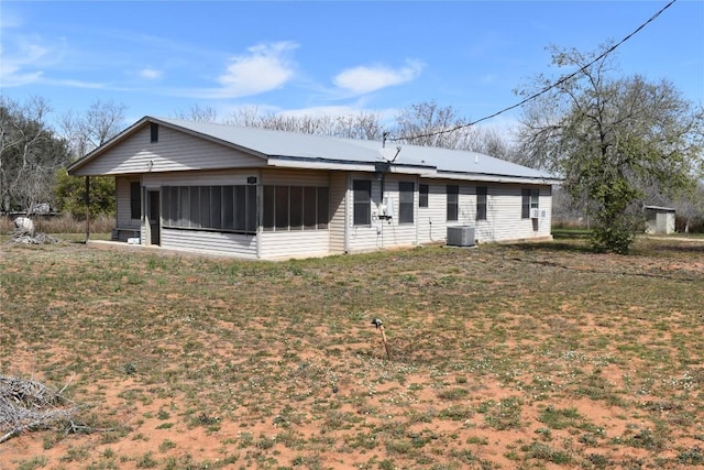 view of front facade with central air condition unit and a sunroom