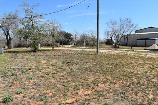 view of yard featuring an outbuilding and central air condition unit