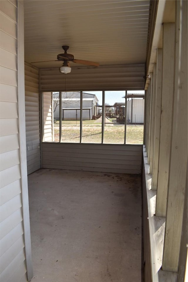 unfurnished sunroom with ceiling fan