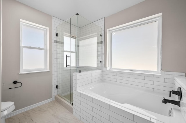 bathroom with toilet, a healthy amount of sunlight, a stall shower, and baseboards