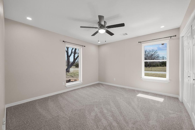 carpeted empty room featuring visible vents, recessed lighting, baseboards, and ceiling fan