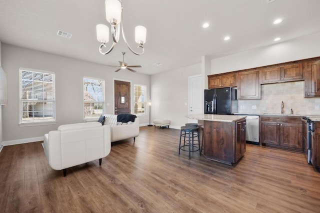 kitchen with visible vents, a kitchen island, decorative backsplash, appliances with stainless steel finishes, and a sink