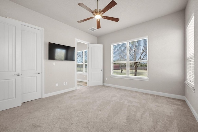 unfurnished bedroom with visible vents, carpet floors, baseboards, and ceiling fan