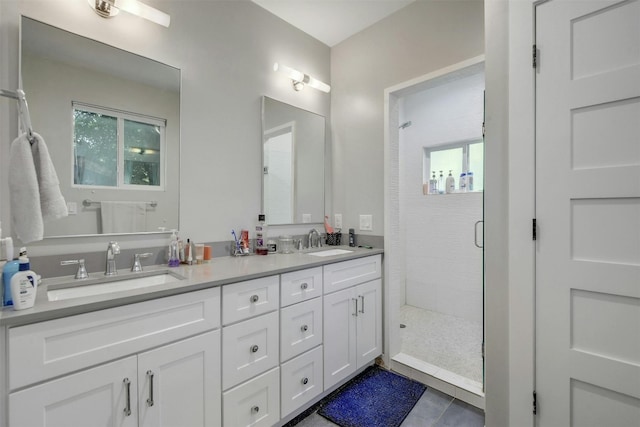 bathroom featuring a sink, double vanity, a shower stall, and tile patterned flooring