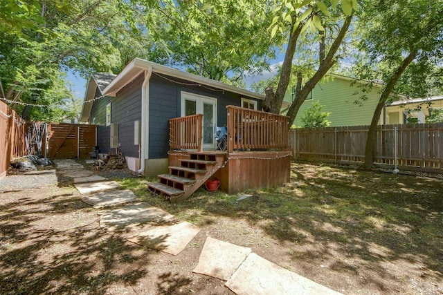 rear view of house with a gate, french doors, and a fenced backyard