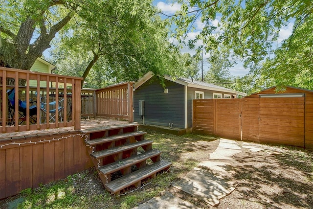 view of yard featuring an outdoor structure, a deck, and fence