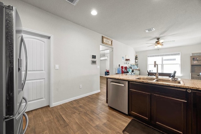 kitchen featuring dark brown cabinetry, visible vents, appliances with stainless steel finishes, and wood finished floors