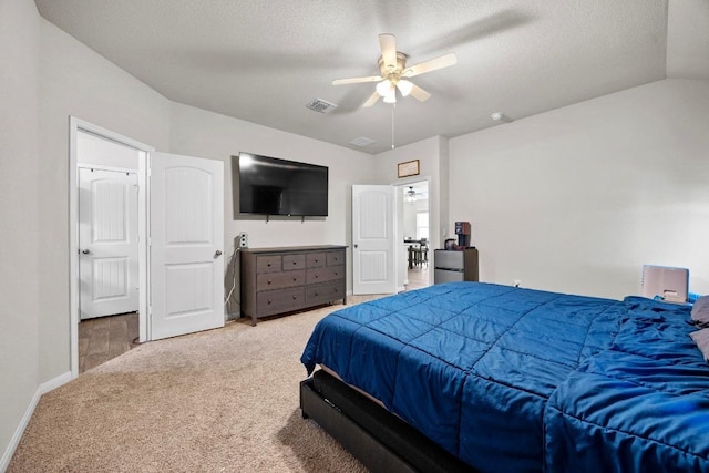 bedroom featuring visible vents, carpet floors, a textured ceiling, and vaulted ceiling