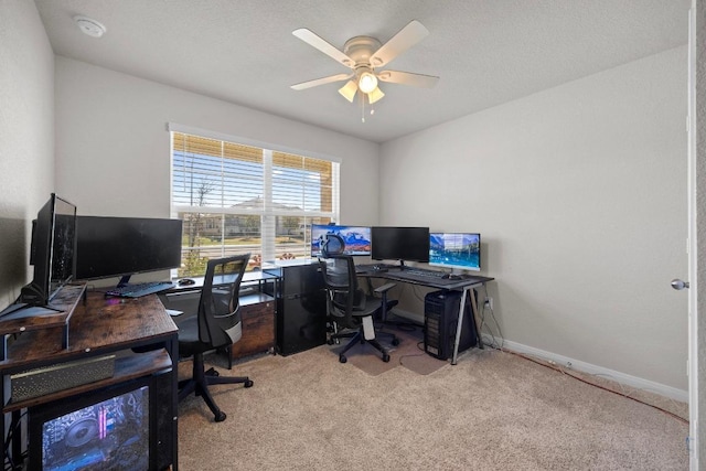 office space with baseboards, light colored carpet, ceiling fan, and a textured ceiling