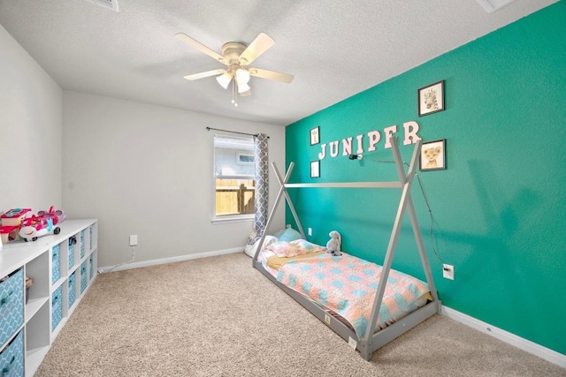 bedroom with a ceiling fan, carpet floors, and a textured ceiling