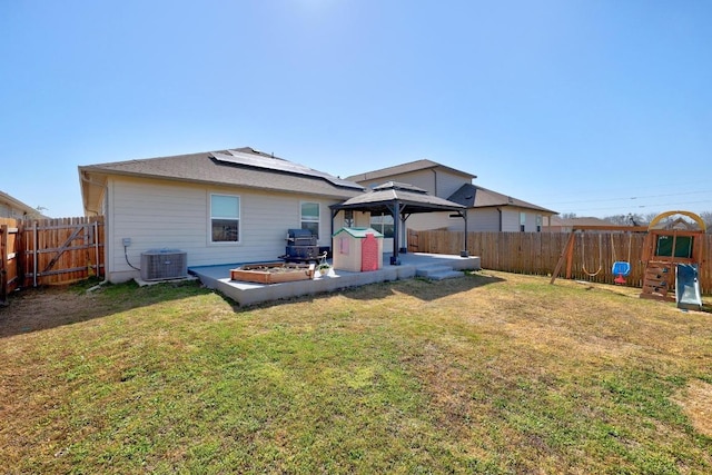 rear view of property featuring a fenced backyard, central AC, a gazebo, a patio area, and a lawn