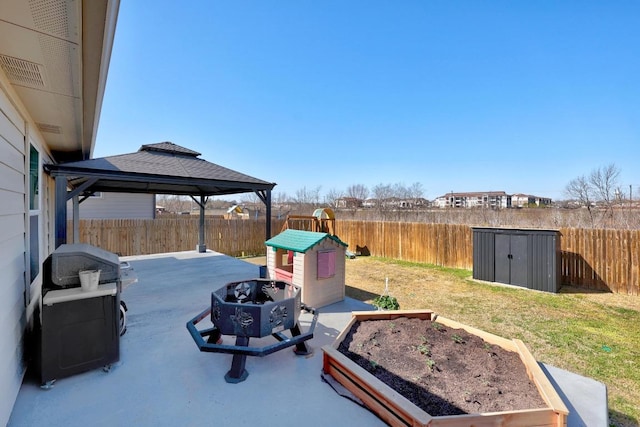 view of yard with a gazebo, a storage shed, a garden, an outbuilding, and a patio